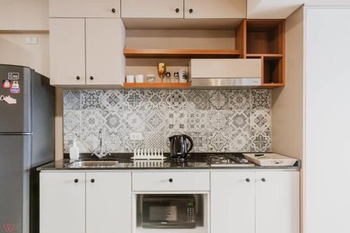 Una cocina con gabinetes blancos y un refrigerador negro. en Cozy 1BR Stunning View in Barranco, en Lima