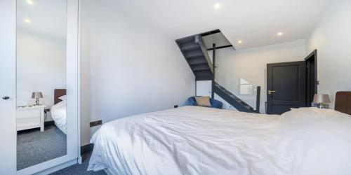 a bedroom with a white bed and a staircase at Elegant 2 Bedroom Apartment in Bromley