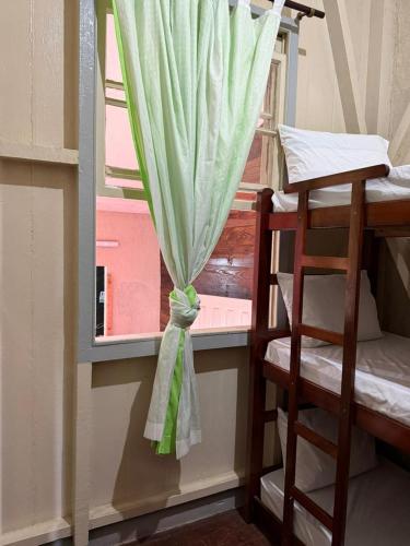 a window with a curtain in a room with bunk beds at Hostel Big Ben in Paranapiacaba