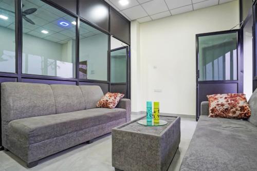 a living room with a couch and a table at Hotel O JANNAT in Nagpur