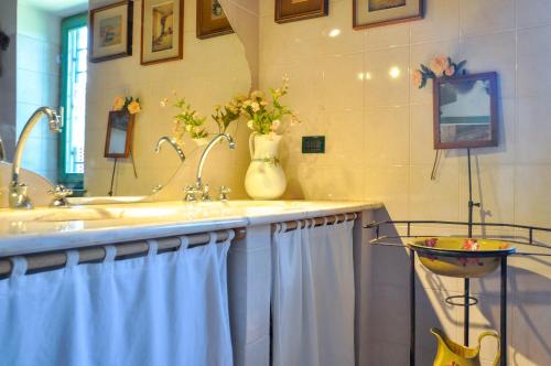 a bathroom with a sink and a vase of flowers at Casa Alta in Pistoia