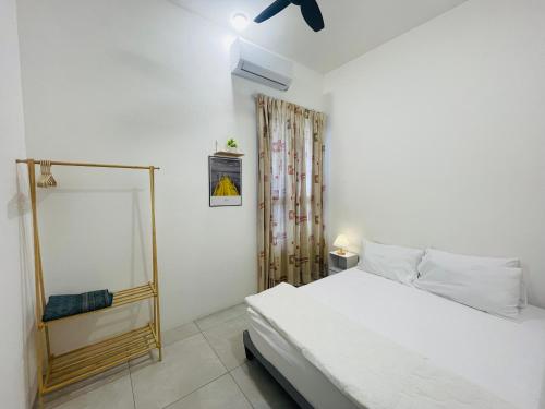 una camera da letto bianca con un letto e una finestra di Aston Acacia Homestay a Bukit Mertajam