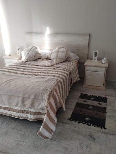a bedroom with a large bed with a striped blanket at Descanso en el Sur in Playa Unión