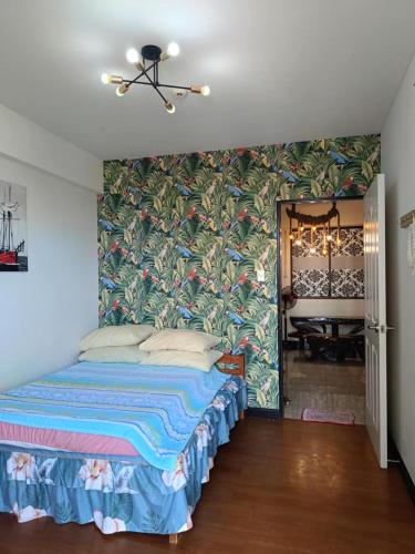 a bedroom with a bed with a floral wallpaper at Davao Condo Chateau Soleil in Davao City