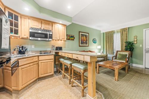 a kitchen with wooden cabinets and a table at Villas of Hatteras Landing by KEES Vacations in Hatteras