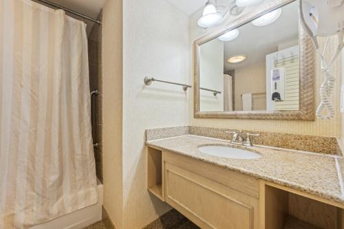 a bathroom with a sink and a mirror at Villas of Hatteras Landing by KEES Vacations in Hatteras