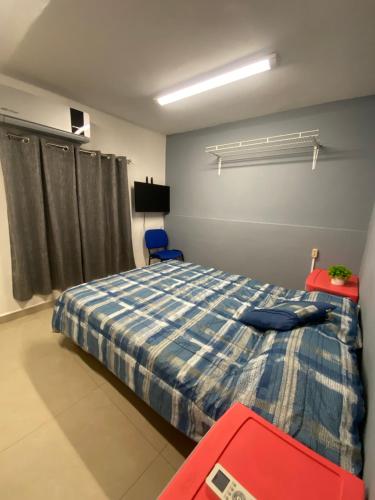 a bedroom with a bed and a red suitcase at Hostal TO3 in Ciudad Madero