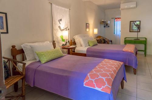 two beds in a room with purple sheets at Creekside Oasis in San Felipe