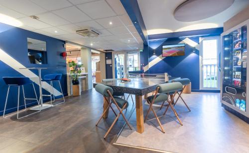 a dining room with blue walls and a table and chairs at ibis Budget Mâcon Sud in Mâcon