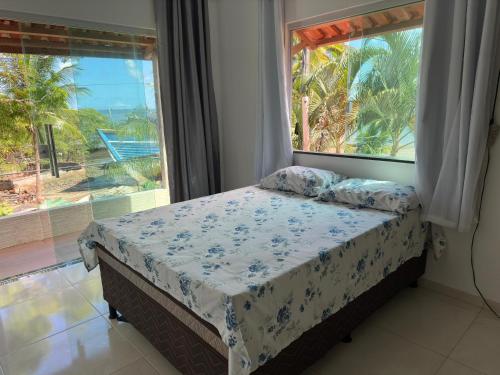 a bedroom with a bed and a large window at Casa da praia Ilha Grande in Camamu