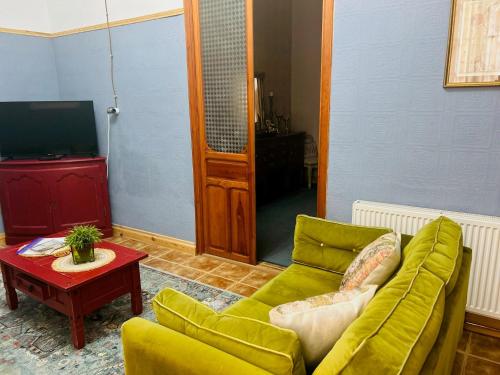 a living room with a green couch and a table at Grande Suite in Pinoso