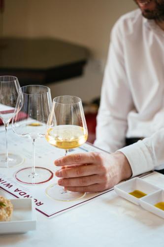 a person sitting at a table with a glass of wine at Hotel Palacio de Hemingway in Ronda