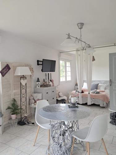un salon avec une table et des chaises et un lit dans l'établissement Le petit gite Normand 15 kilomètres de Honfleur, à Manneville-la-Raoult