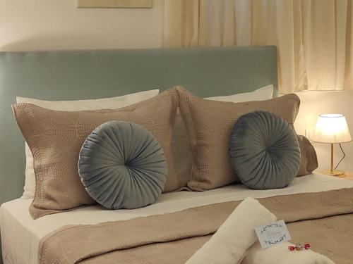 a bed with two blue pillows on top of it at CORFU TENNIS Studios in Agios Rokkos