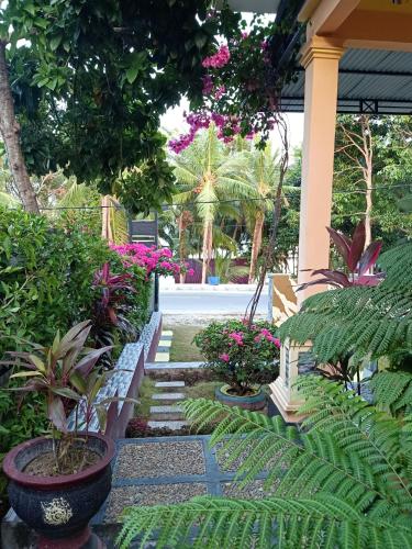 a garden with plants and flowers on a building at Wambuliga Homestay in Waha