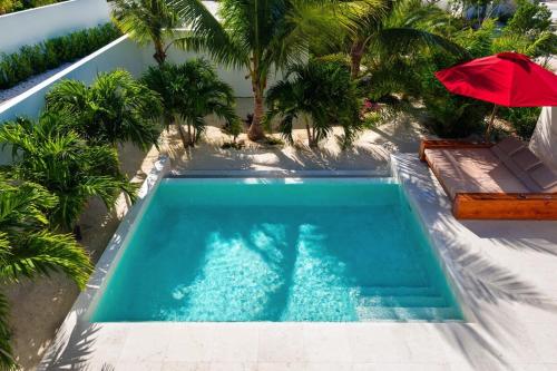 an overhead view of a swimming pool with a red umbrella at Contemporary Luxury one-bedroom beach villa in Providenciales