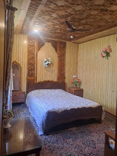 a bedroom with a large bed and a wooden ceiling at Smith palace group of houseboats in Srinagar