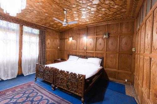 a bedroom with a bed with wooden walls and a ceiling at Smith palace group of houseboats in Srinagar