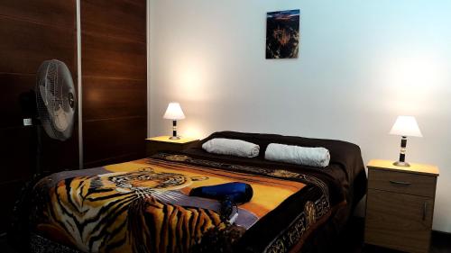 une chambre avec un lit à motif tigre dans l'établissement Cómodo y moderno departamento con cochera, a pasos de la principal calle comercial de la ciudad, à La Plata