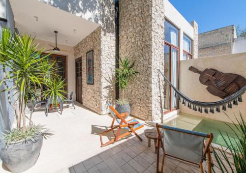 Un patio con una guitarra en la pared de un edificio. en FREE PRIVATE PARKING Casa Trova en Santa Lucía Centro Mérida, en Mérida