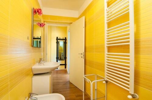 a yellow bathroom with a sink and a toilet at Residence Florida B03 - a 200m dal lungolago - in Lazise
