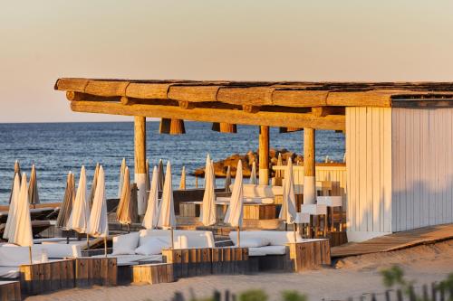 a group of chairs and umbrellas on the beach at Hôtel Plage Palace & Spa in Palavas-les-Flots