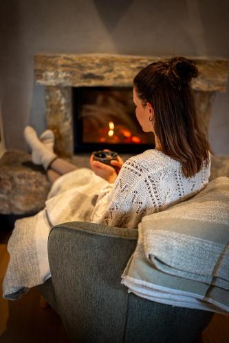 a woman sitting in a chair in front of a fireplace at Naturhof eibl in Grossarl