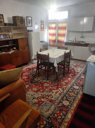 ein Wohnzimmer mit einem Tisch und Stühlen auf einem Teppich in der Unterkunft Konak Anja 