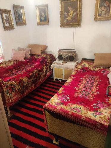 ein Schlafzimmer mit 2 Betten und einem Tisch mit Bildern an der Wand in der Unterkunft Konak Anja 