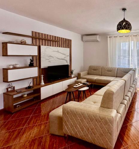 a living room with a couch and a flat screen tv at Lumiere in Përmet