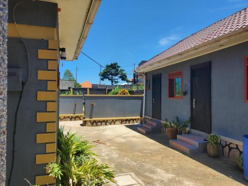 a house with a balcony with a gate and a door at Alice Gardens & Campsite in Entebbe