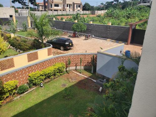 a car parked in a yard in front of a house at Alice Gardens & Campsite in Entebbe