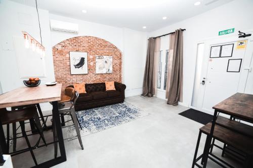 a living room with a couch and a brick wall at Hotel Maruja en Cascorro in Madrid