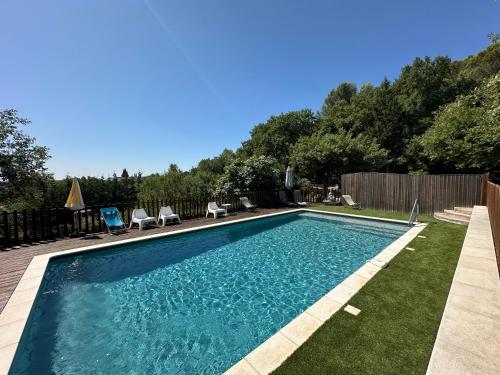 - une piscine dans une cour avec des chaises et des arbres dans l'établissement Maison Bleu Avril - Gard, à Saint-Nazaire