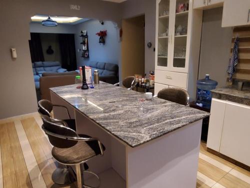 a kitchen with a counter and a living room at Alice Gardens and Campsite in Entebbe