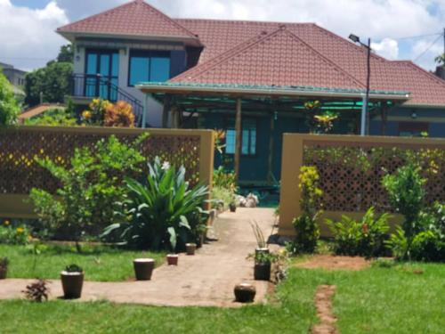a house with a garden in front of it at Alice Gardens and Campsite in Entebbe
