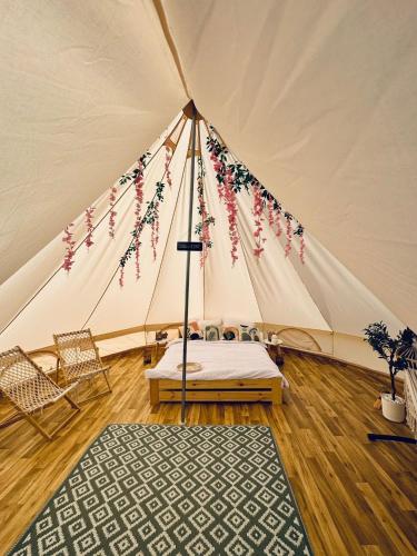 a tent with a bed and a rug in a room at New Generation Camp in Siedliska