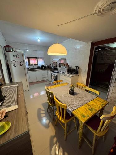 a kitchen with a table and chairs and a kitchen with a refrigerator at Hostel Casa Jambo Guaruja in Guarujá
