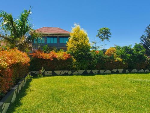 a garden with a house in the background at Alice Gardens and Campsite in Entebbe