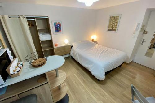 une chambre avec un lit blanc et une table dans l'établissement Studio near the city center, à Montpellier