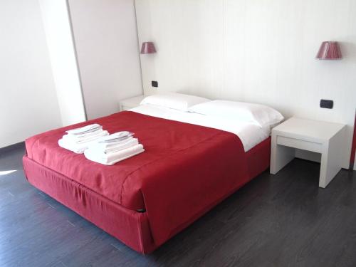 a red bed with white sheets and a red blanket at Areté Luxury Room in Reggio Calabria