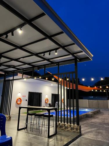 a pergola with a table and a pool at The Rina Homestay-Whole Villa with Private Pool,BBQ & Karaoke-Near Beach- in Port Dickson