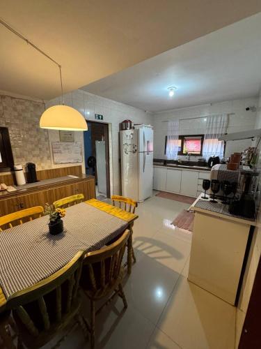 a kitchen and dining room with a table and a refrigerator at Hostel Casa Jambo Guaruja in Guarujá