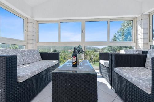 a living room with two couches and a table at Villa Almas with swimming pool, tennis court, sauna, gym, grill house in Neorić