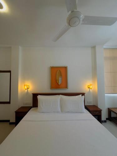 a white bed with two pillows in a bedroom at Alloy Heights Hotel & Apartments in Kandy