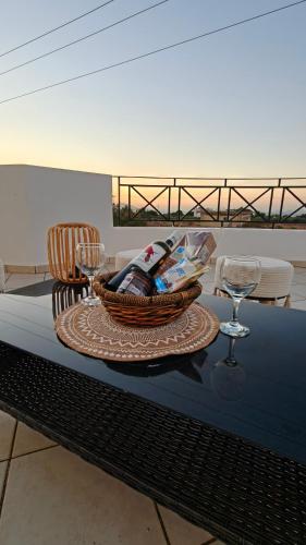 a table with a basket and wine glasses on it at Villa Aphrodity in Kos Town