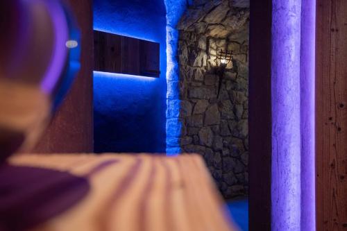 a blue light in a room with a stone wall at Posthotel Erlerwirt in Erl