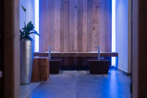 a wooden bench with potted plants in a room at Posthotel Erlerwirt in Erl