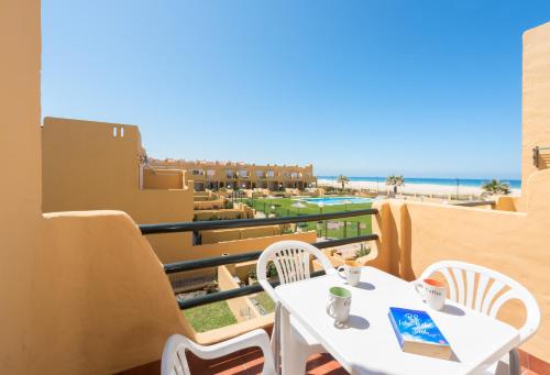 balcón con mesa y sillas y vistas a la playa en Apartamento Los Lances I, en Tarifa