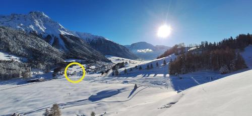 a yellow circle in the snow on a mountain at Reschnerhof in Resia
